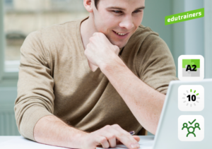 jongeman kijkt lachend naar laptop
